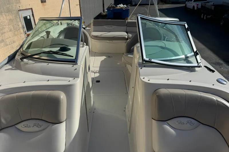 Slide: The Image of 2005 Sea Ray 240 Sundeck boat interior with dual windshields and seating. - 23