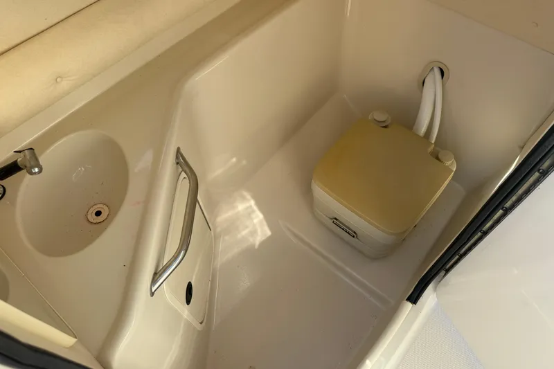 Slide: The Image of 2005 Sea Ray 240 Sundeck interior with sink and portable toilet. - 3