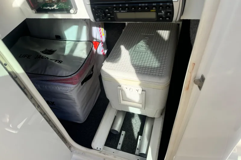 Slide: The Image of Storage area in a 2005 Sea Ray 240 Sundeck with life jackets and cooler. - 4