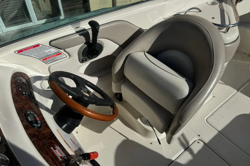 Slide: The Image of 2005 Sea Ray 240 Sundeck helm with steering wheel and captain's chair. - 5