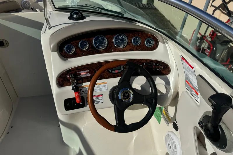Slide: The Image of 2005 Sea Ray 240 Sundeck boat dashboard with gauges and steering wheel. - 6