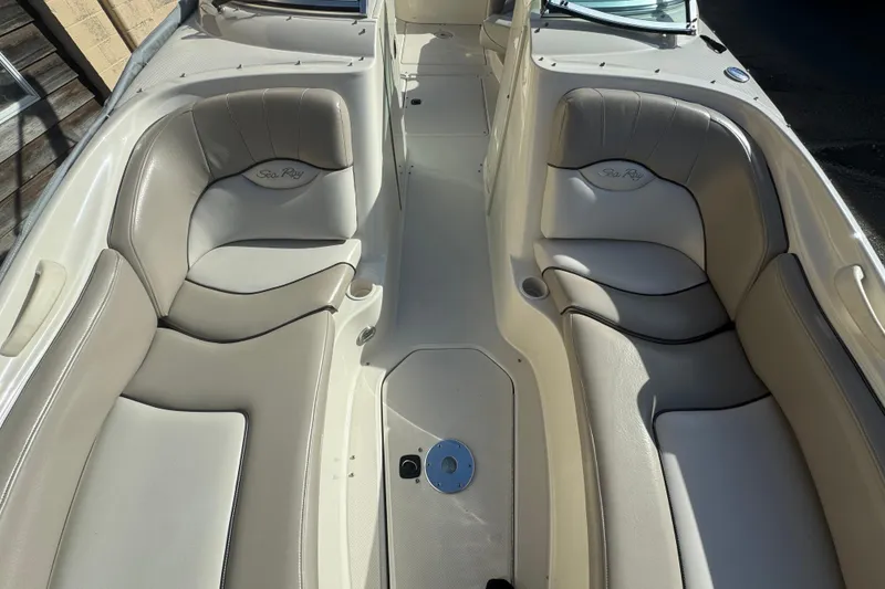 Slide: The Image of 2005 Sea Ray 240 Sundeck interior with beige seating and cup holders. - 8