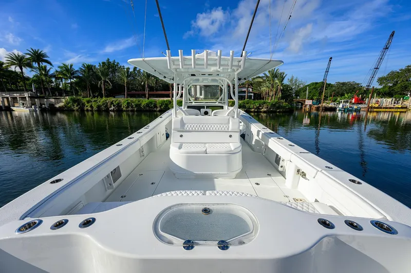 Slide: The Image of 2021 Yellowfin 39 Offshore boat on calm water, surrounded by lush greenery and blue sky. - 11