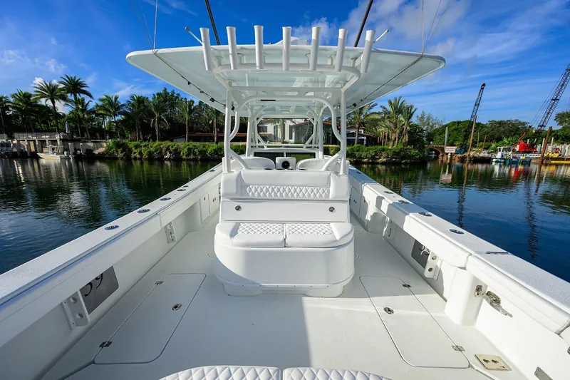 Slide: The Image of 2021 Yellowfin 39 Offshore boat, spacious deck, luxurious seating, docked by palm trees. - 12
