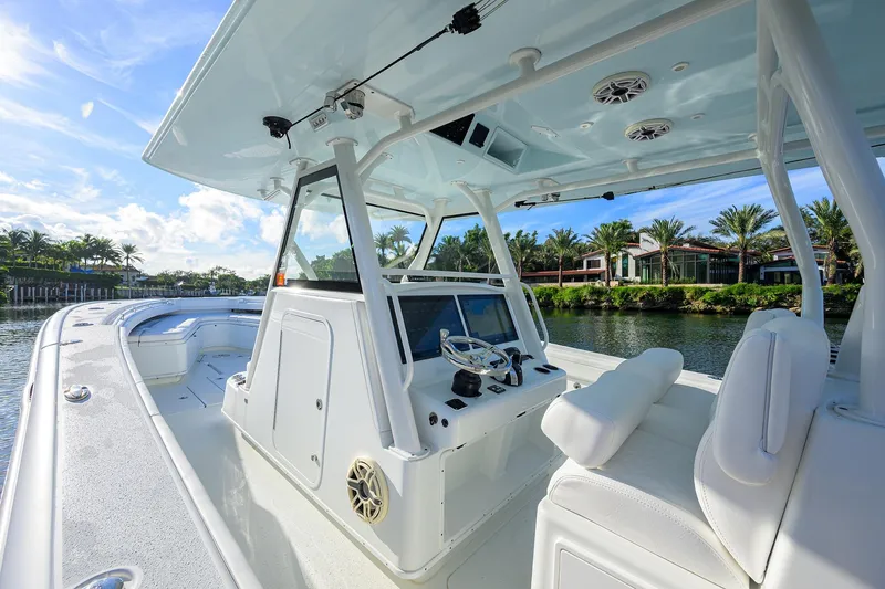 Slide: The Image of 2021 Yellowfin 39 Offshore boat interior with helm, white seating, and waterfront view. - 18