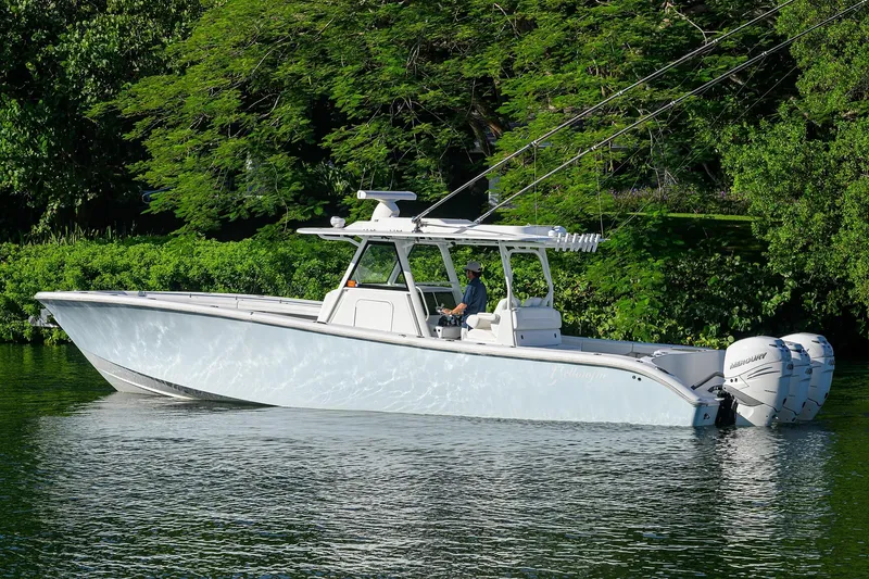 Slide: The Image of 2021 Yellowfin 39 Offshore boat on calm water, surrounded by lush greenery. - 2