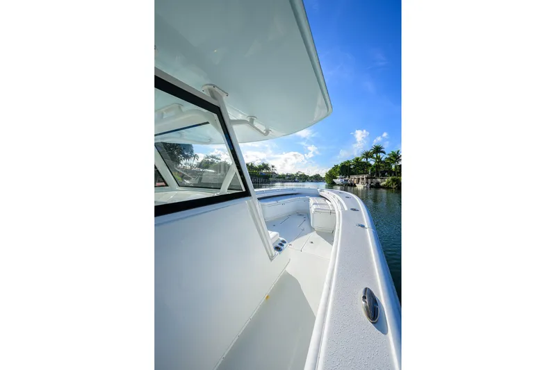 Slide: The Image of 2021 Yellowfin 39 Offshore boat on a sunny day, docked by palm trees. - 22