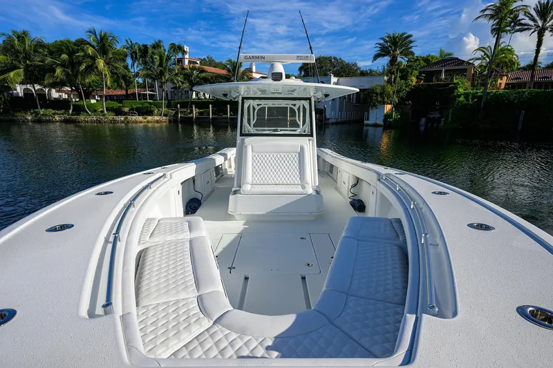 Slide: The Image of 2021 Yellowfin 39 Offshore boat with spacious seating, docked by lush greenery. - 23
