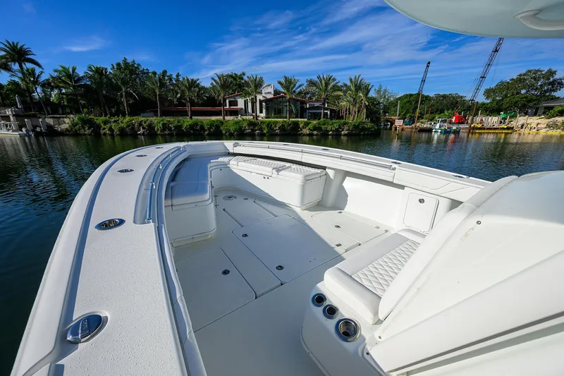 Slide: The Image of 2021 Yellowfin 39 Offshore boat with spacious deck, docked by lush greenery. - 24