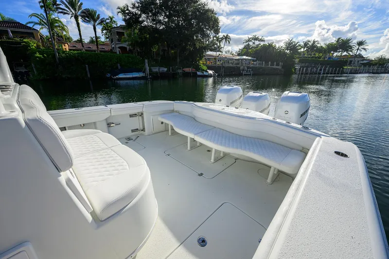 Slide: The Image of 2021 Yellowfin 39 Offshore boat with white seating and triple engines on a calm waterway. - 30