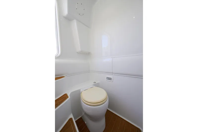 Slide: The Image of 2021 Yellowfin 39 Offshore boat bathroom with white walls and wooden flooring. - 40