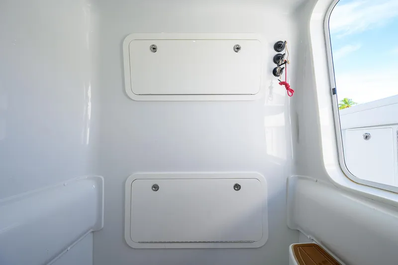 Slide: The Image of 2021 Yellowfin 39 Offshore interior with storage compartments and window view. - 43