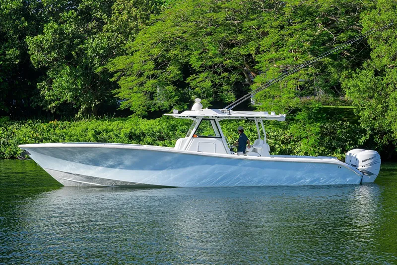 Slide: The Image of 2021 Yellowfin 39 Offshore boat on calm water, surrounded by lush greenery. - 5