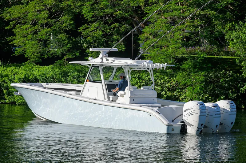 Slide: The Image of 2021 Yellowfin 39 Offshore boat with triple Mercury engines on a serene waterway. - 7