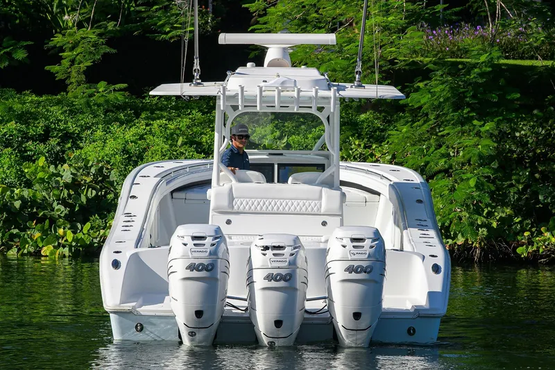 Slide: The Image of 2021 Yellowfin 39 Offshore boat with triple 400 horsepower engines on a lush waterway. - 8