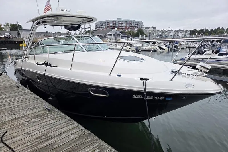 The Image of 2008 Sea Ray 290 Amberjack docked at a marina with waterfront buildings. - 1