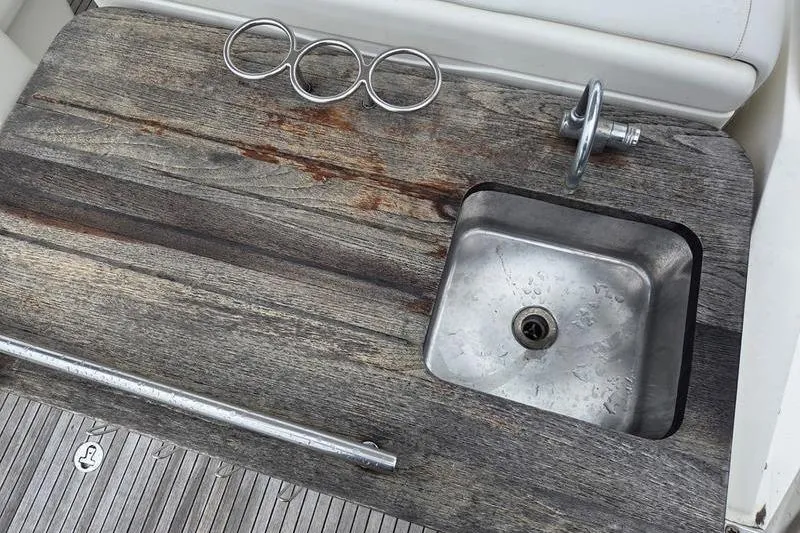 Slide: The Image of 2008 Sea Ray 290 Amberjack boat sink with weathered wood countertop and cup holders. - 10