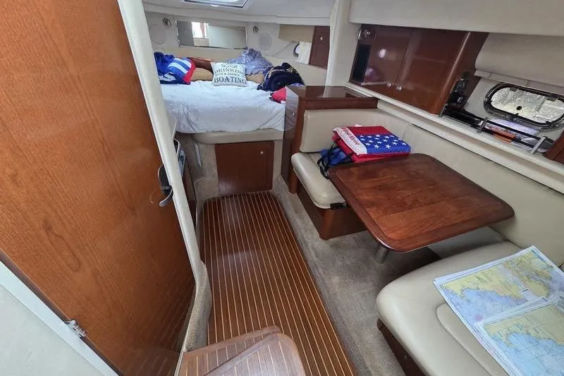 Slide: The Image of 2008 Sea Ray 290 Amberjack cabin interior with bed, table, and nautical decor. - 22