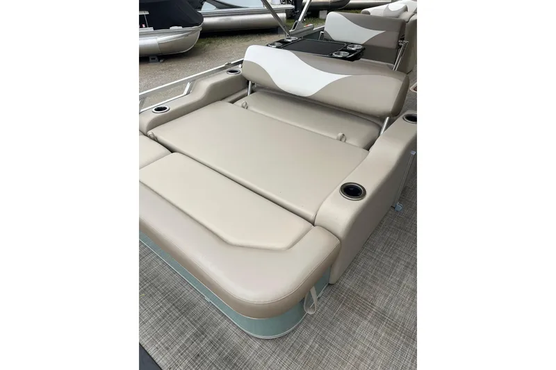 Slide: The Image of 2026 Tahoe 25 LTZ Entertainer boat interior with beige seating and cup holders. - 3