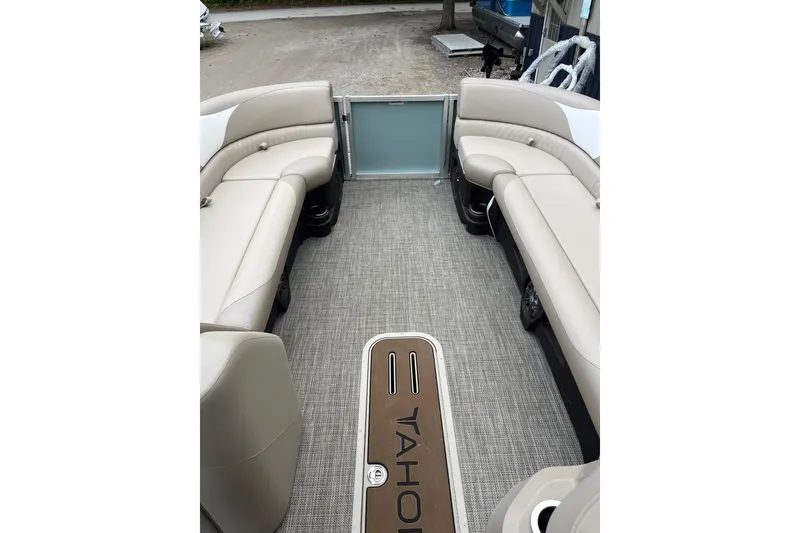 Slide: The Image of 2026 Tahoe 25 LTZ Entertainer boat interior with beige seating and carpeted floor. - 9