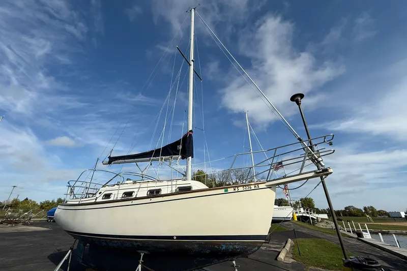 Slide: The Image of 1988 Island Packet 27 sailboat on land under a clear blue sky. - 10