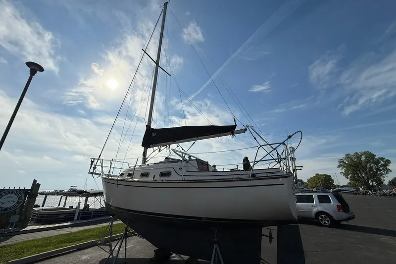 Slide: The Image of 1988 Island Packet 27 sailboat on land under a bright blue sky. - 12