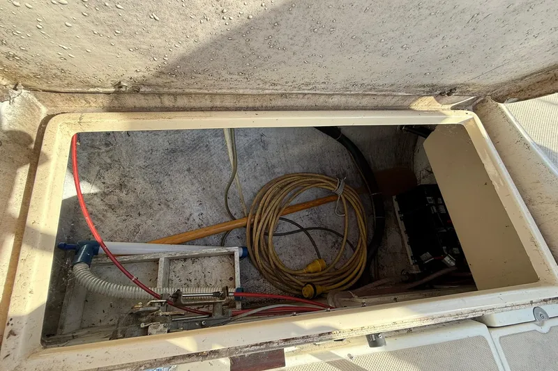 Slide: The Image of Storage compartment of 1988 Island Packet 27 sailboat with coiled ropes and equipment. - 17