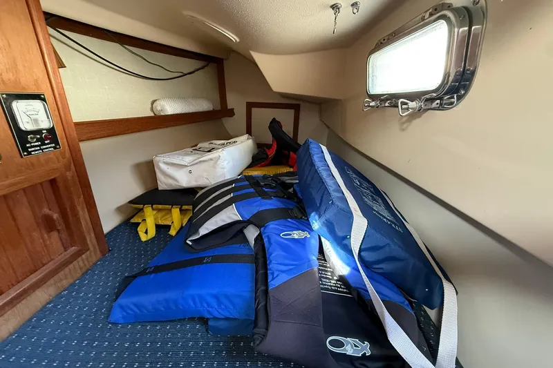 Slide: The Image of Interior of 1988 Island Packet 27 sailboat with life jackets and storage. - 24