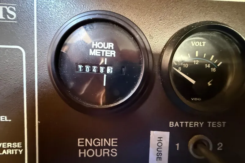 Slide: The Image of Hour meter and volt gauge on 1988 Island Packet 27 boat dashboard. - 26