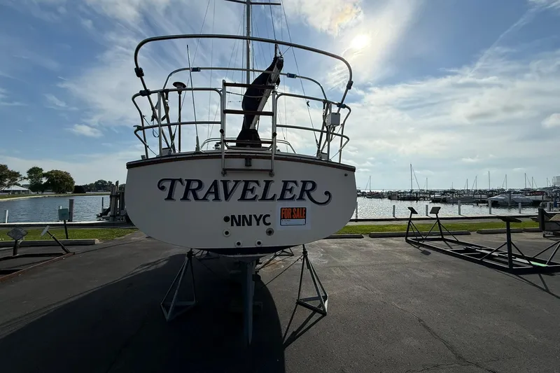 Slide: The Image of 1988 Island Packet 27 sailboat named "Traveler" for sale, docked near a marina. - 3