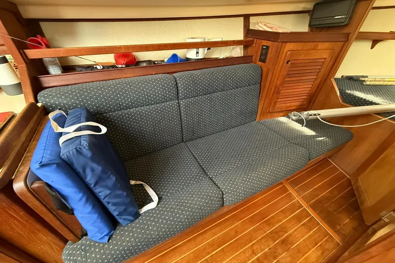 Slide: The Image of Interior of 1988 Island Packet 27 sailboat with blue cushioned seating. - 31