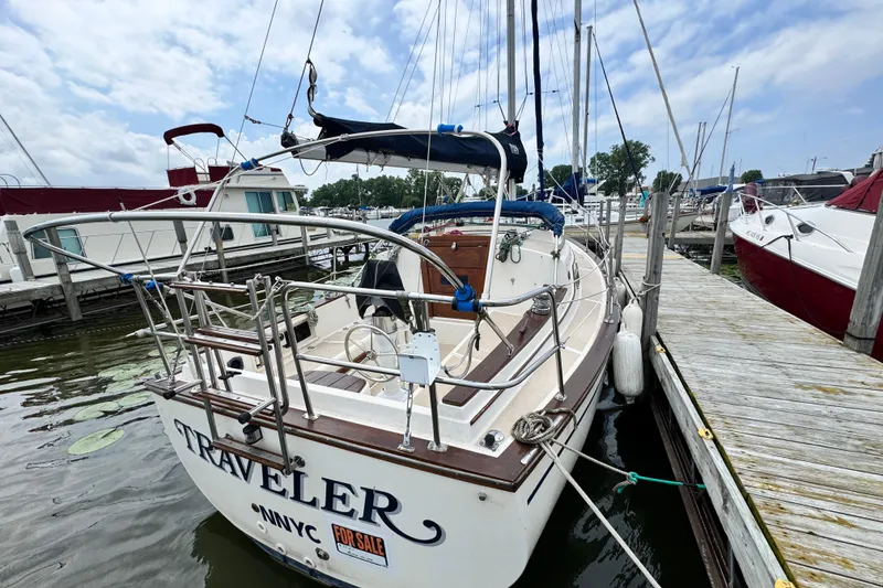 Slide: The Image of 1988 Island Packet 27 sailboat docked, named "Traveler," with a "For Sale" sign. - 4