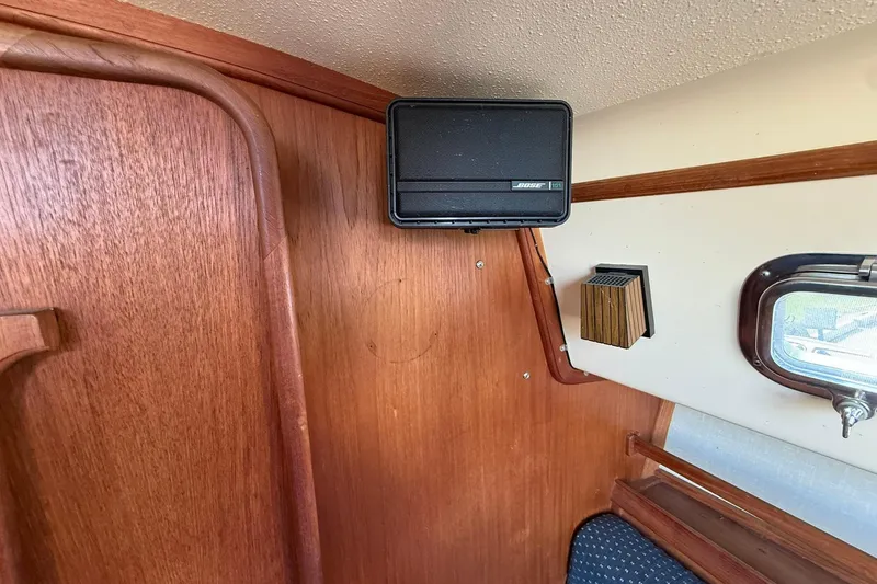 Slide: The Image of Interior of 1988 Island Packet 27 sailboat with speaker and wooden paneling. - 33
