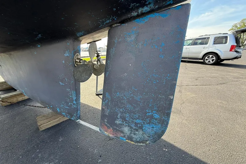 Slide: The Image of 1988 Island Packet 27 sailboat keel and propeller on display in a parking lot. - 4