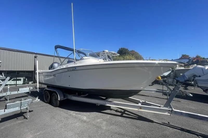The Image of 2012 Grady-White Freedom 255 boat on trailer, parked outdoors under clear blue sky. - 1