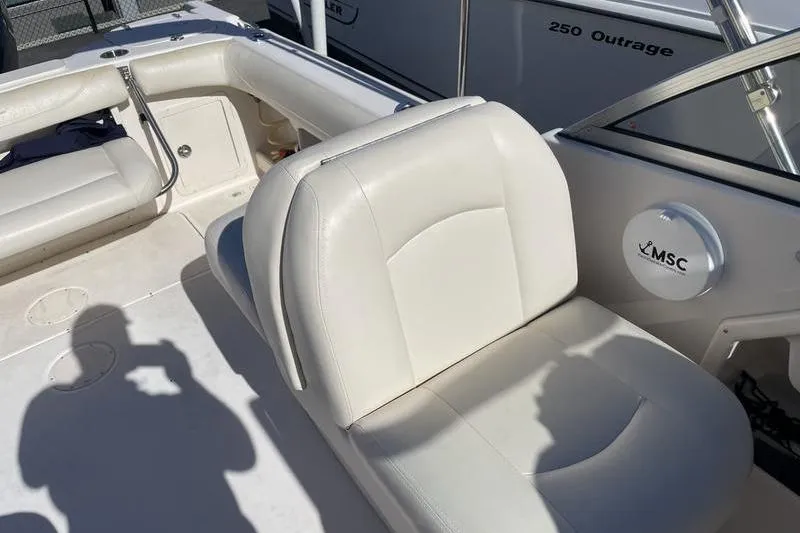 Slide: The Image of 2012 Grady-White Freedom 255 boat interior with white seating and steering area. - 10