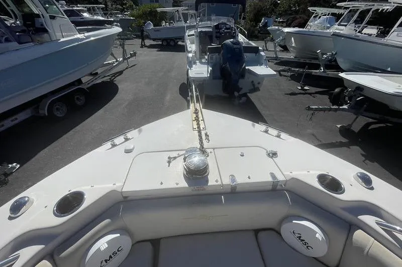 Slide: The Image of 2012 Grady-White Freedom 255 boat in a marina, surrounded by other vessels. - 16