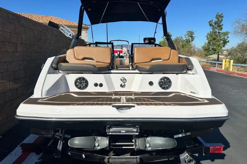 Slide: The Image of 2019 Scarab 215 Wake ID boat on trailer, parked outdoors, showcasing sleek design and seating. - 5