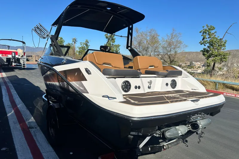 Slide: The Image of 2019 Scarab 215 Wake ID boat on trailer, rear view, showcasing dual engines. - 6