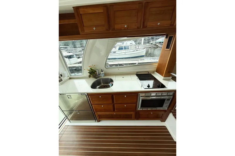 Slide: The Image of Luxurious 2016 Back Cove 41 yacht kitchen with wood cabinetry and modern appliances. - 10