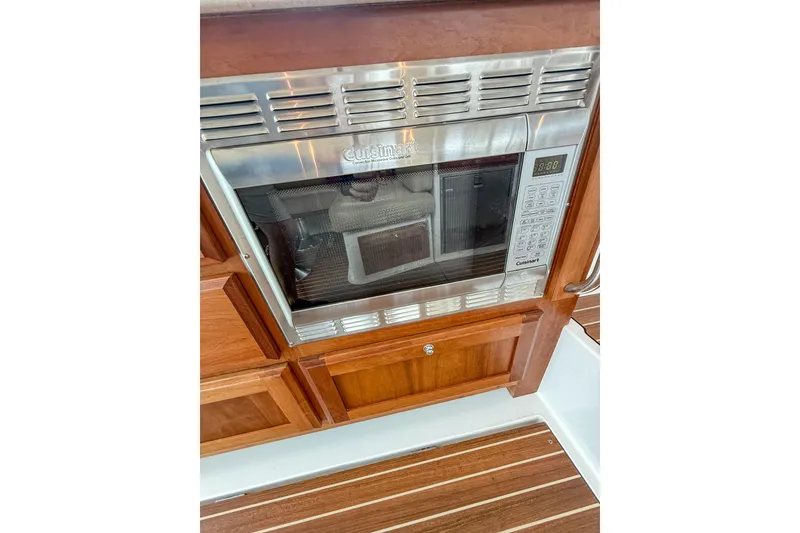 Slide: The Image of Built-in microwave in 2016 Back Cove 41 yacht kitchen, featuring wooden cabinetry and stainless steel finish. - 12