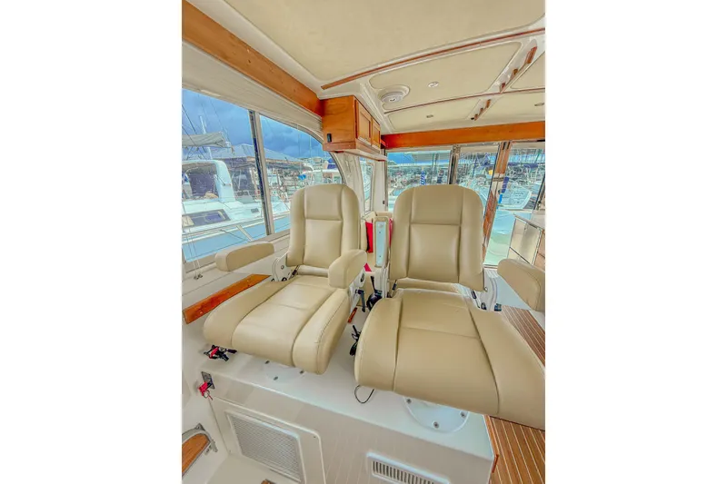 Slide: The Image of Interior of 2016 Back Cove 41 yacht with beige captain's chairs and panoramic windows. - 16