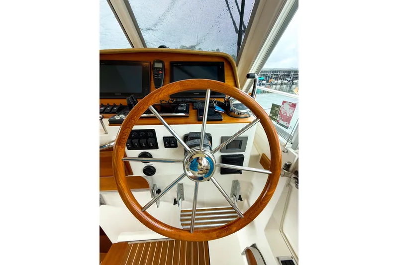 Slide: The Image of Steering wheel and dashboard of a 2016 Back Cove 41 boat, featuring navigation equipment. - 20