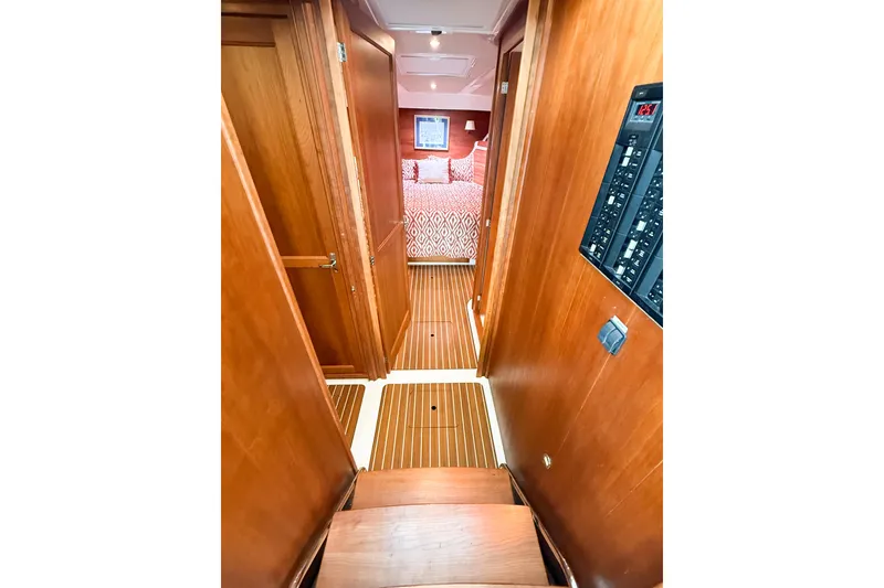 Slide: The Image of 2016 Back Cove 41 yacht interior hallway with wood paneling and bedroom view. - 27