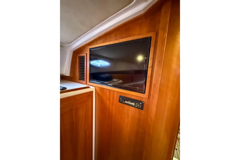 Slide: The Image of 2016 Back Cove 41 interior with mounted TV and wooden paneling. - 31