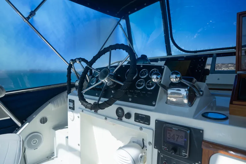 Slide: The Image of Cockpit of 1984 Bertram 35 Convertible boat with steering wheel and navigation instruments. - 14