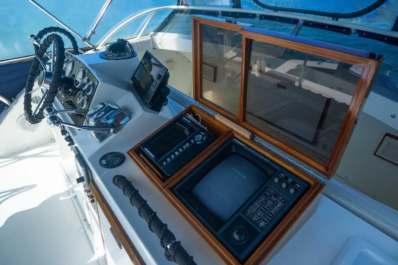 Slide: The Image of 1984 Bertram 35 Convertible helm with vintage navigation equipment and steering wheel. - 15