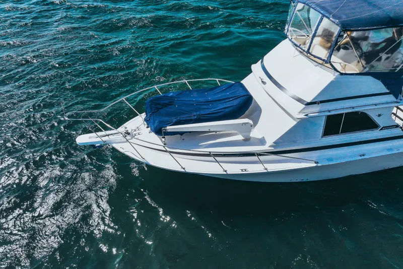 Slide: The Image of 1984 Bertram 35 Convertible yacht on open water, aerial view. - 2