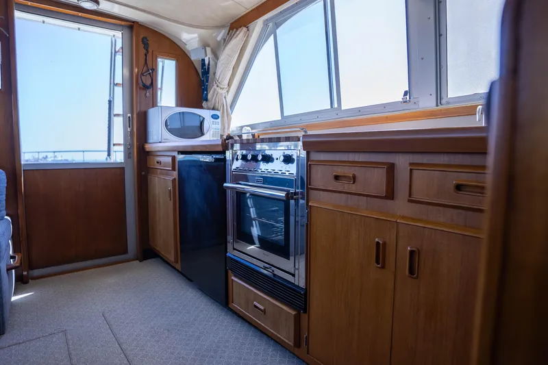 Slide: The Image of Interior of 1984 Bertram 35 Convertible yacht kitchen with stove, microwave, and wooden cabinets. - 22