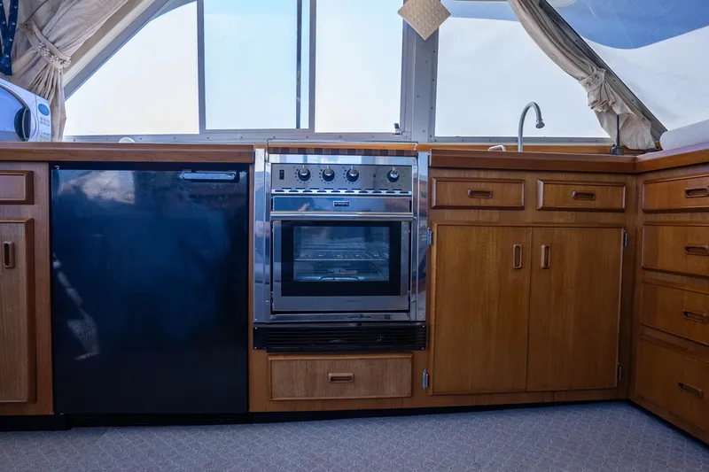 Slide: The Image of 1984 Bertram 35 Convertible yacht kitchen with wood cabinets and modern appliances. - 23